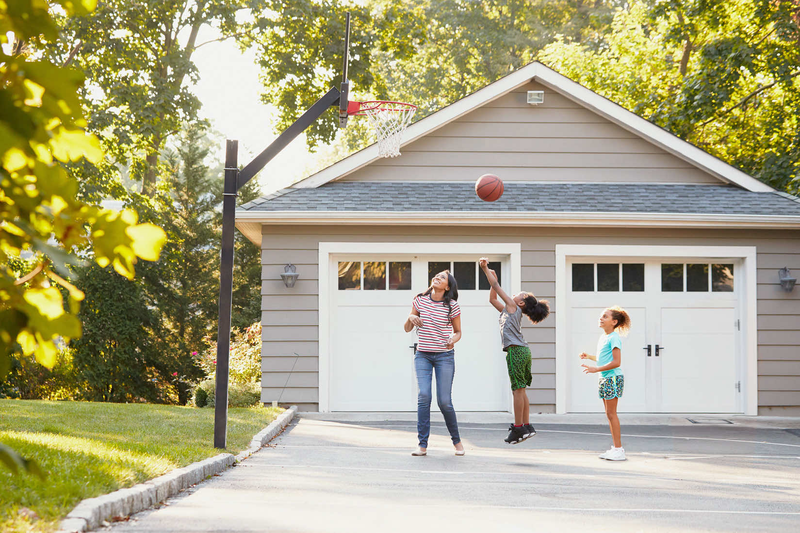 A family enjoying basketball in their driveway