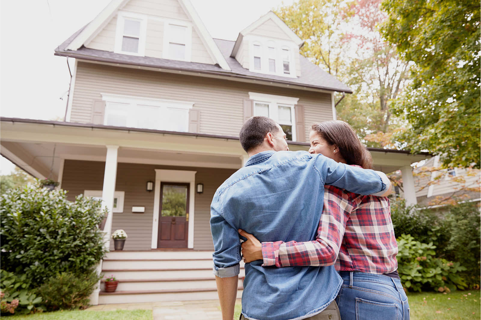 Couple embracing in front of their new home