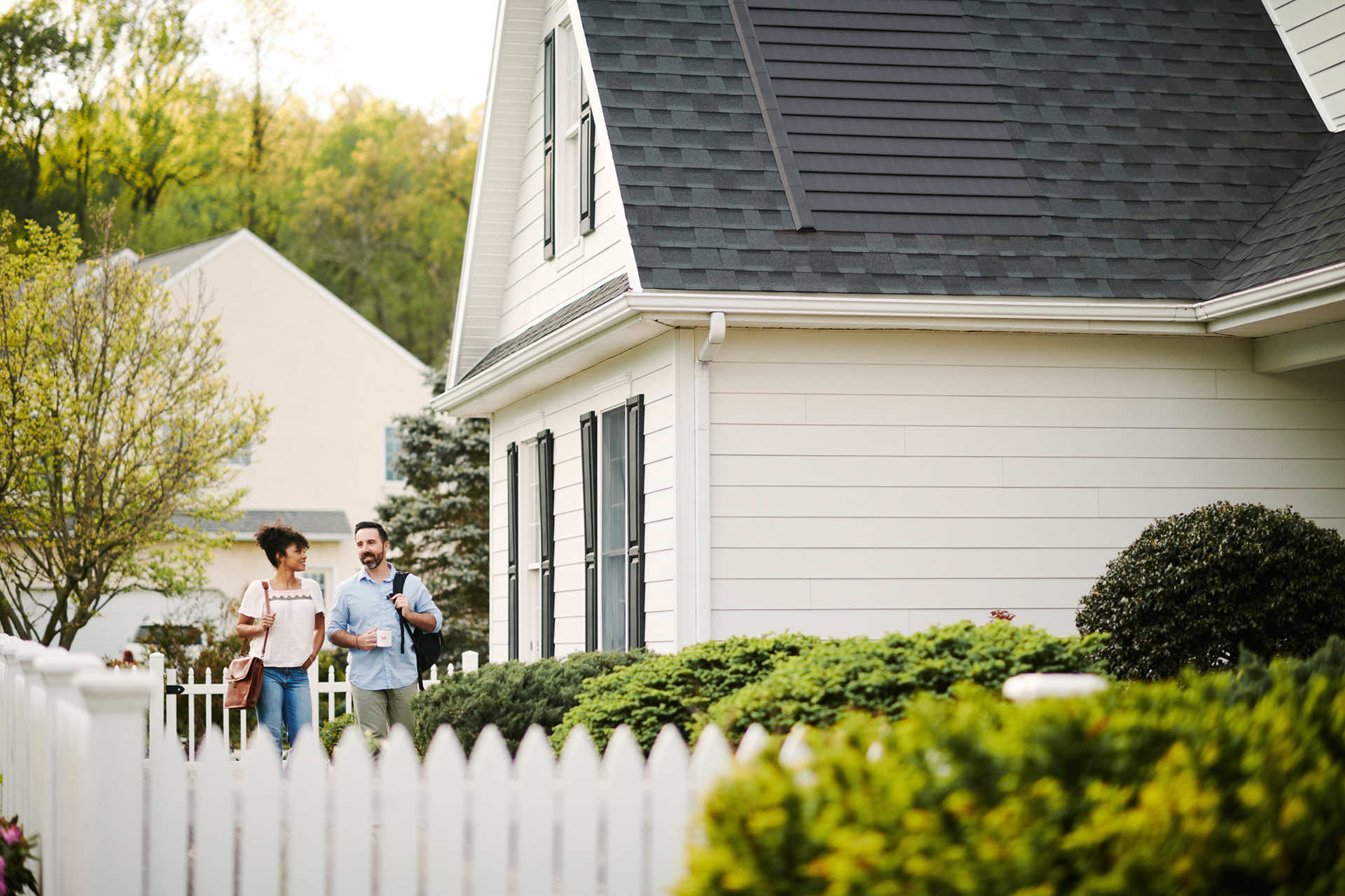 A couple walking past their home