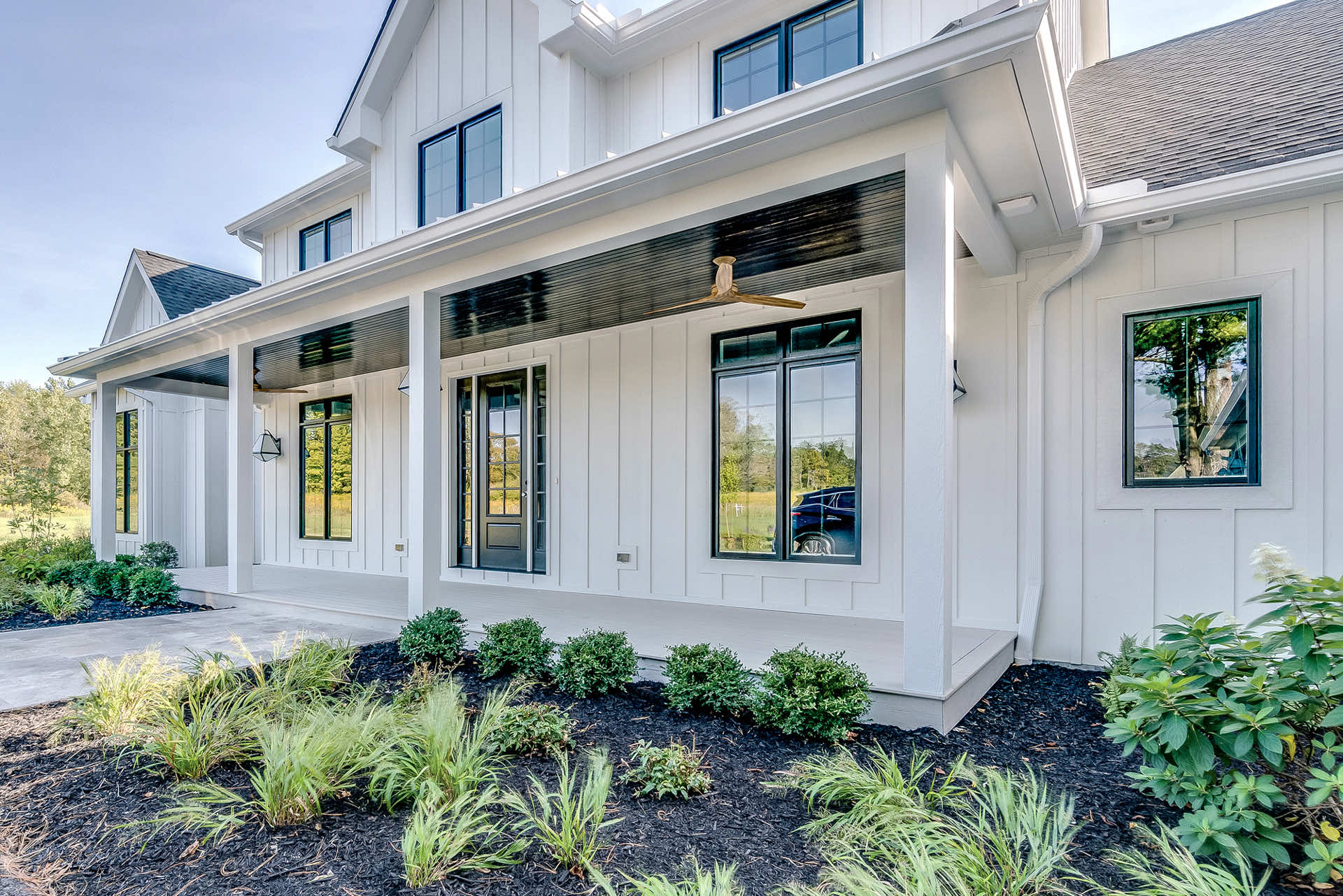 View of a modern home exterior with white siding and landscaping