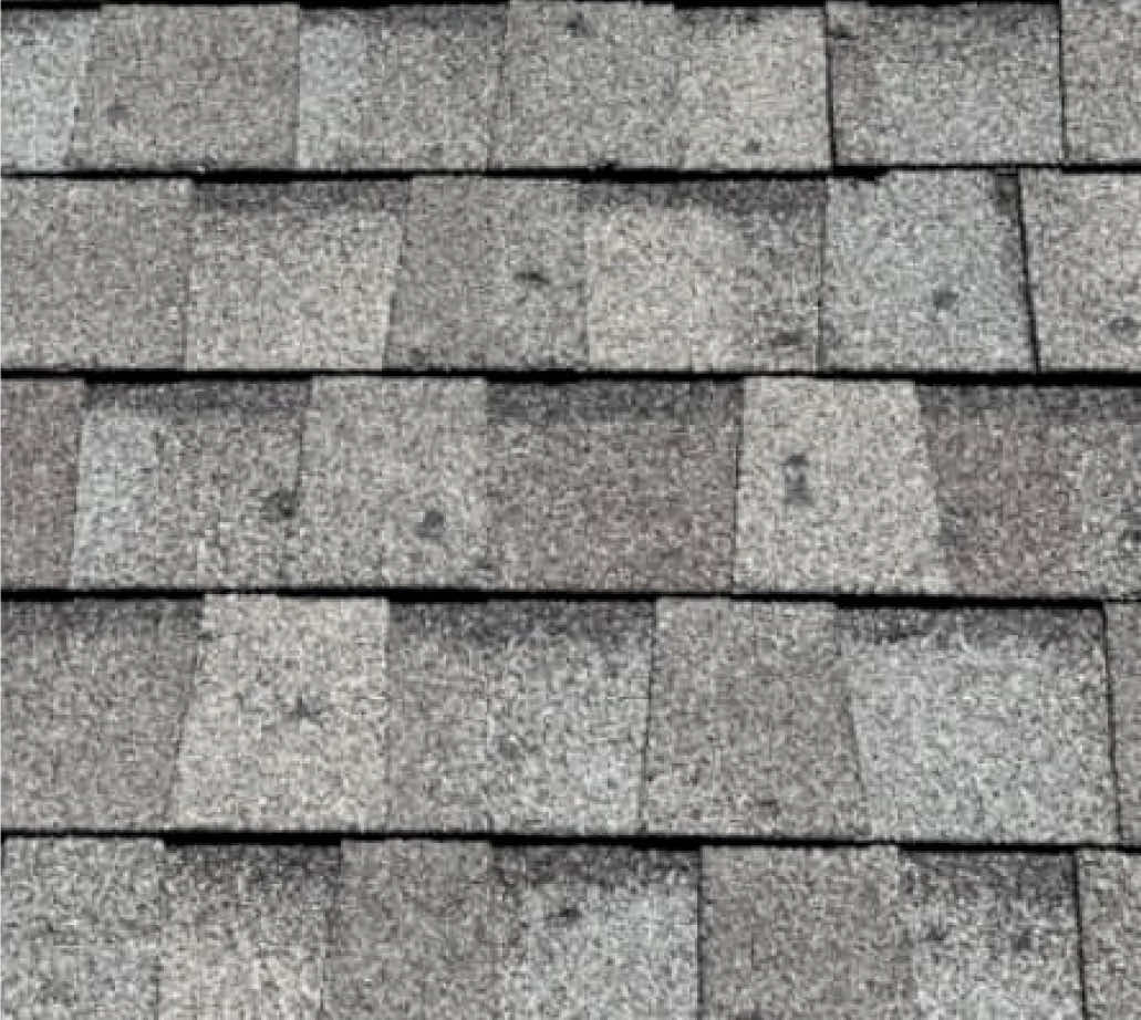 Close-up view of asphalt roof shingles in varying shades of gray.