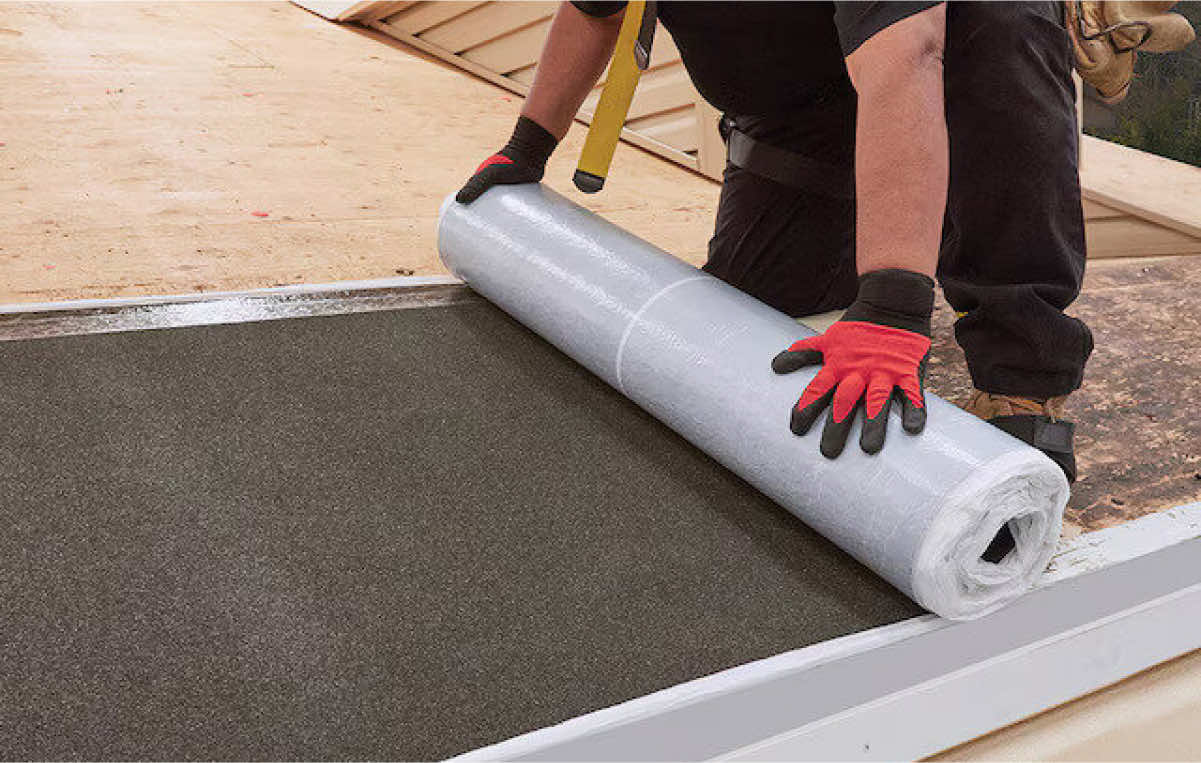 Person installing roofing material on a construction site