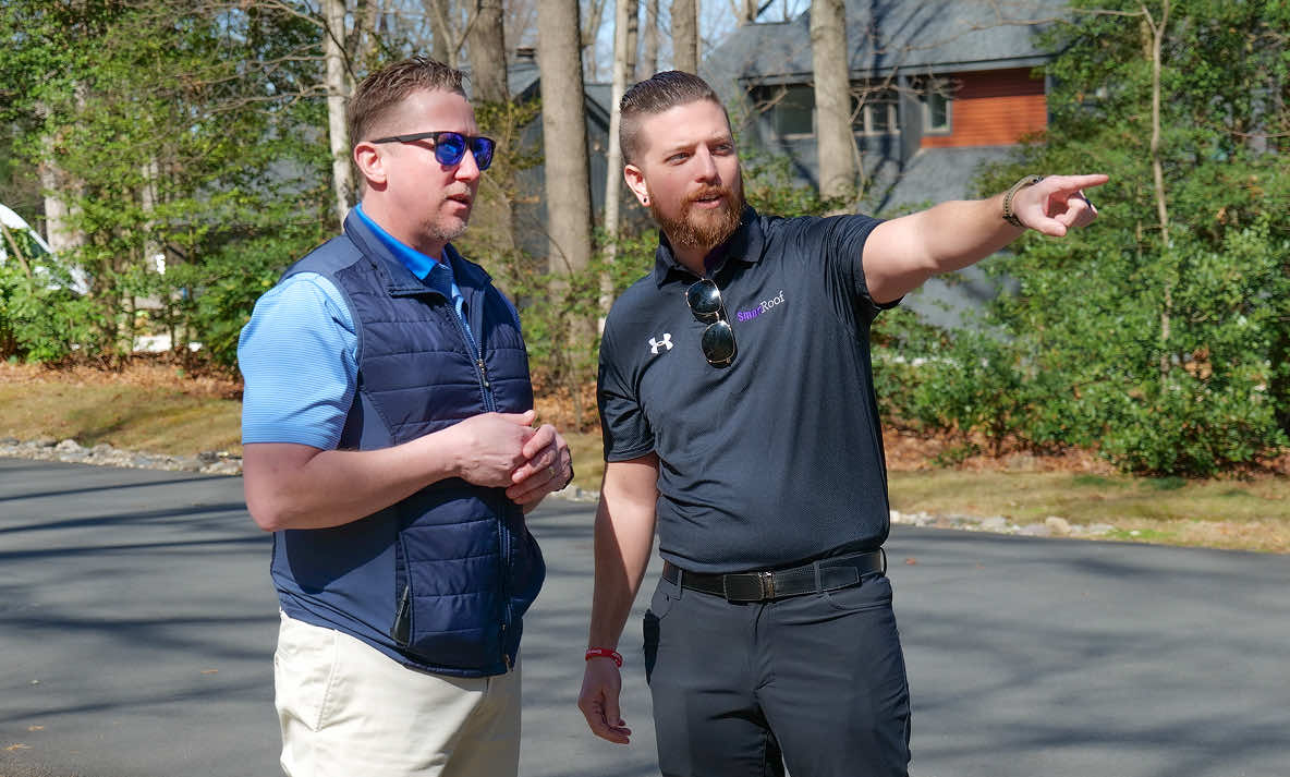 Two members of the SmartRoof team discussing a project outdoors.