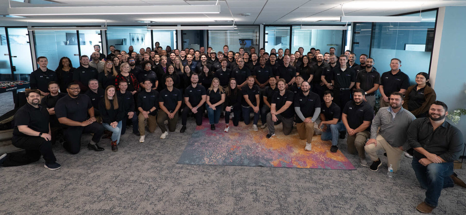 Team photo of SmartRoof employees in a modern office setting
