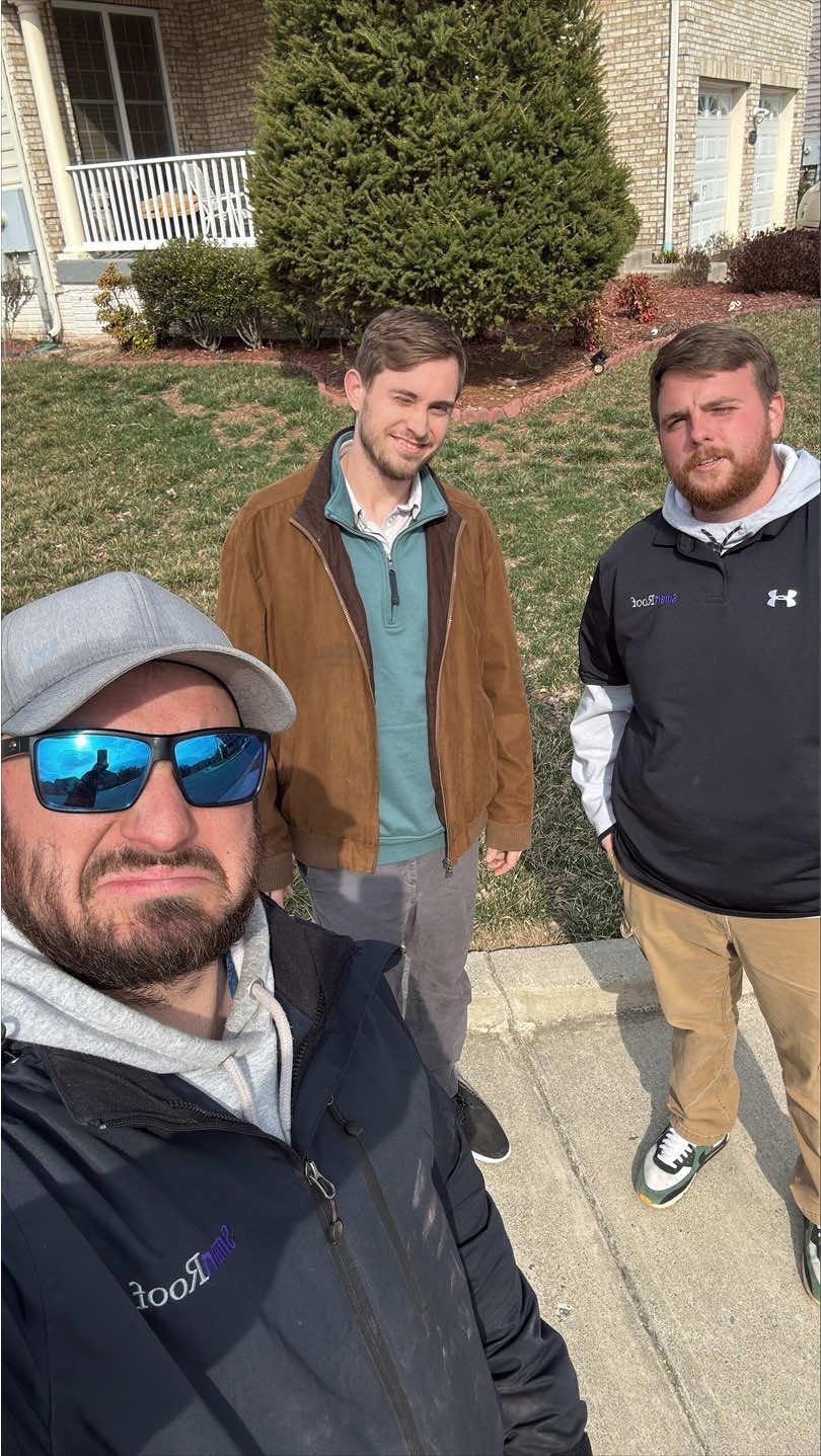 SmartRoof team members posing outdoors in front of a house.