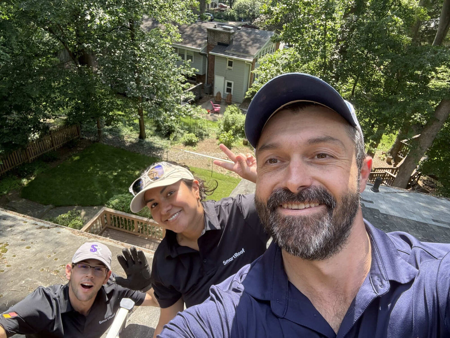 Team members of SmartRoof taking a selfie on the roof during installation work.