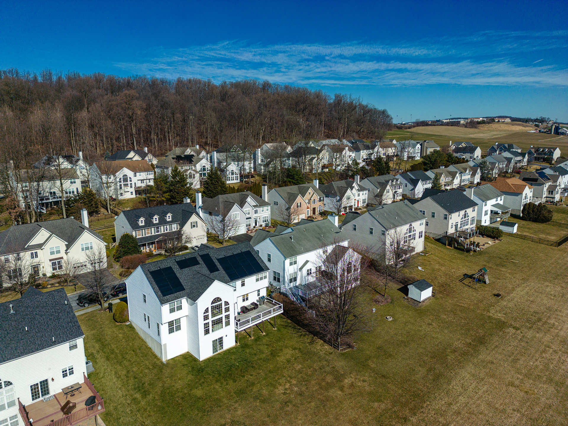 Aerial view of residential homes featuring solar panels on rooftops