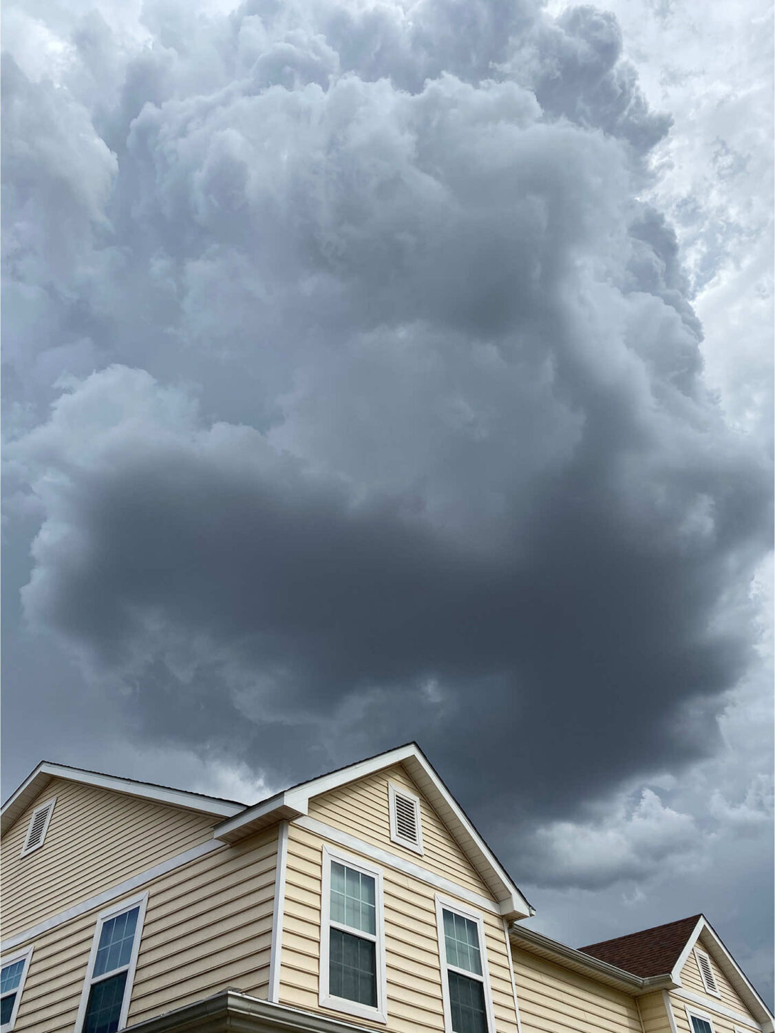 Dramatic storm clouds looming over a residential house